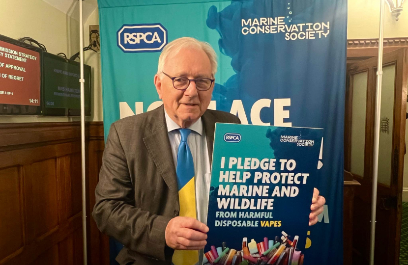 Sir Peter Bottomley posing with an article headline describing the harm of single-use vapes