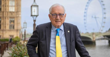 Sir Peter standing in front of Parliament