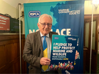 Sir Peter Bottomley posing with an article headline describing the harm of single-use vapes